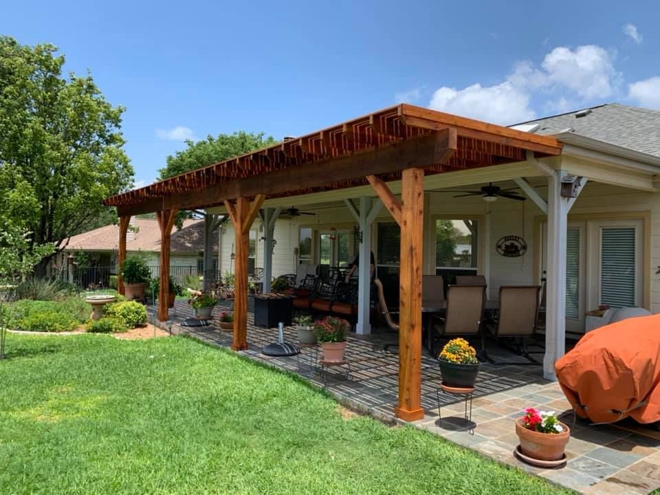 There is a pergola in the backyard of a house.