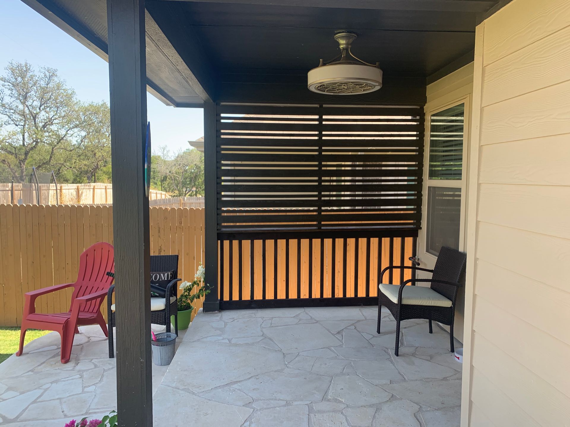 A patio with chairs, a table, and a ceiling fan.