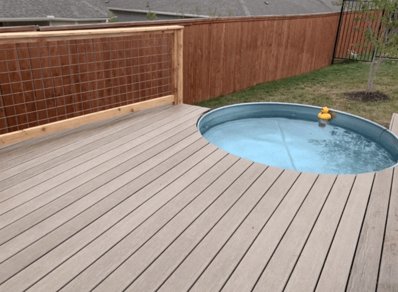 A wooden deck with a small pool in the middle of it.