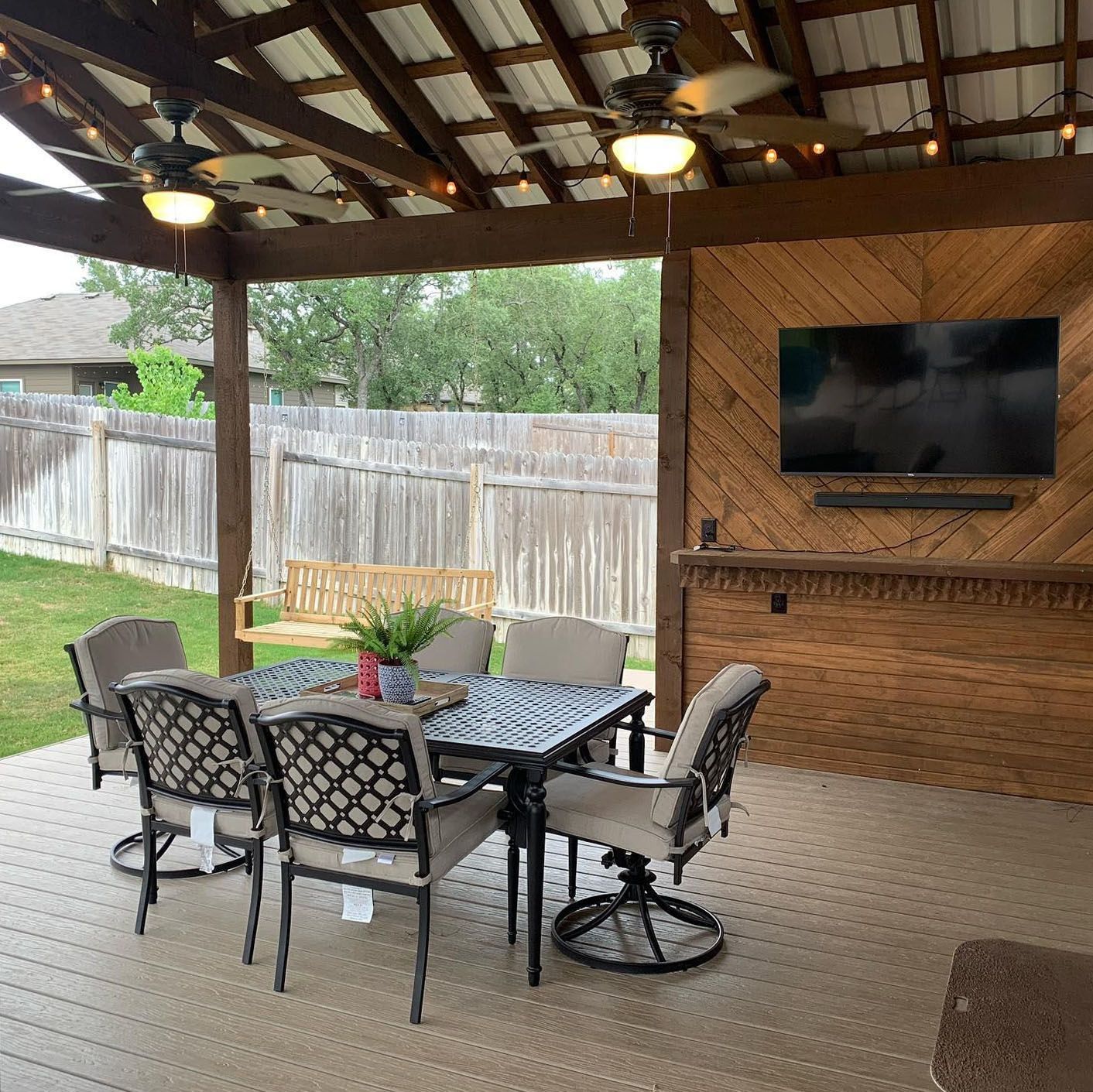 A patio with a table and chairs and a television on the wall.