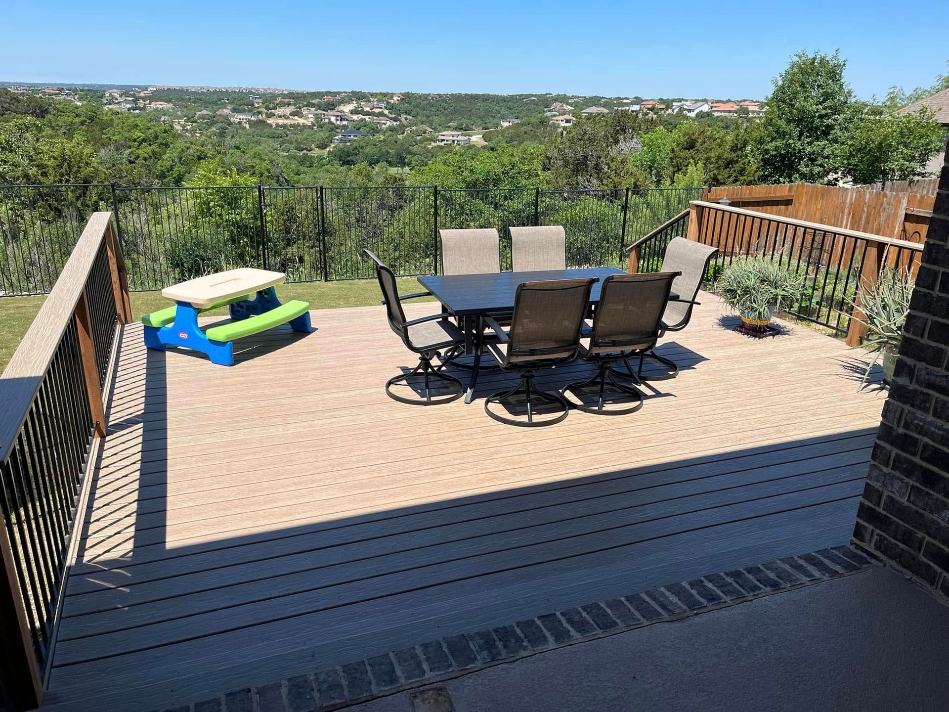 A deck with a table and chairs and a picnic table.