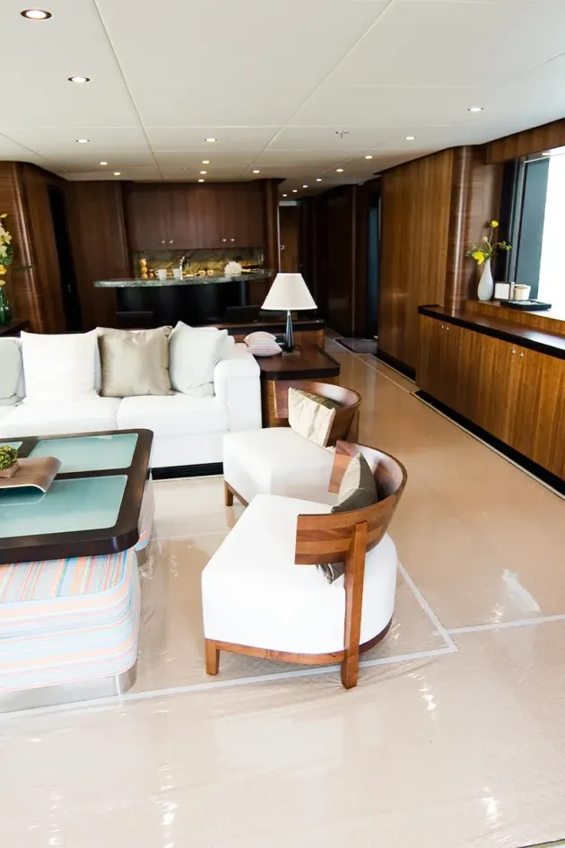 Modern living room with white sofa, round chairs, wood paneling, and large windows