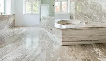 Bright white marble bathroom with a built-in tub, large windows, and a matching vanity.