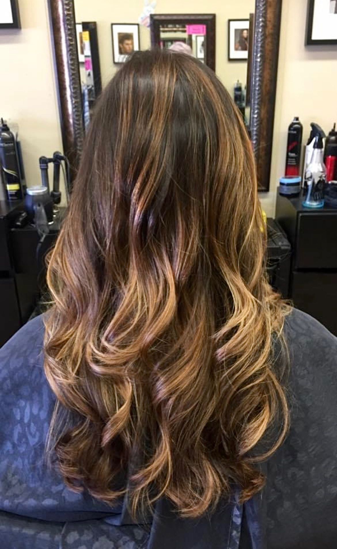 a woman is sitting in a chair with her hair in a salon