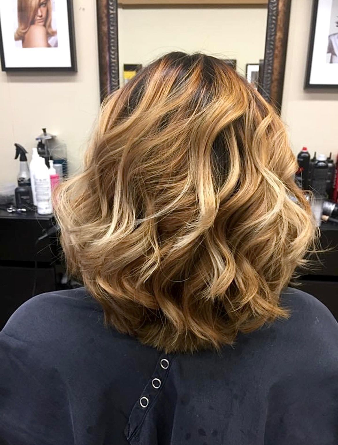 a woman with blonde hair is sitting in a chair in front of a mirror