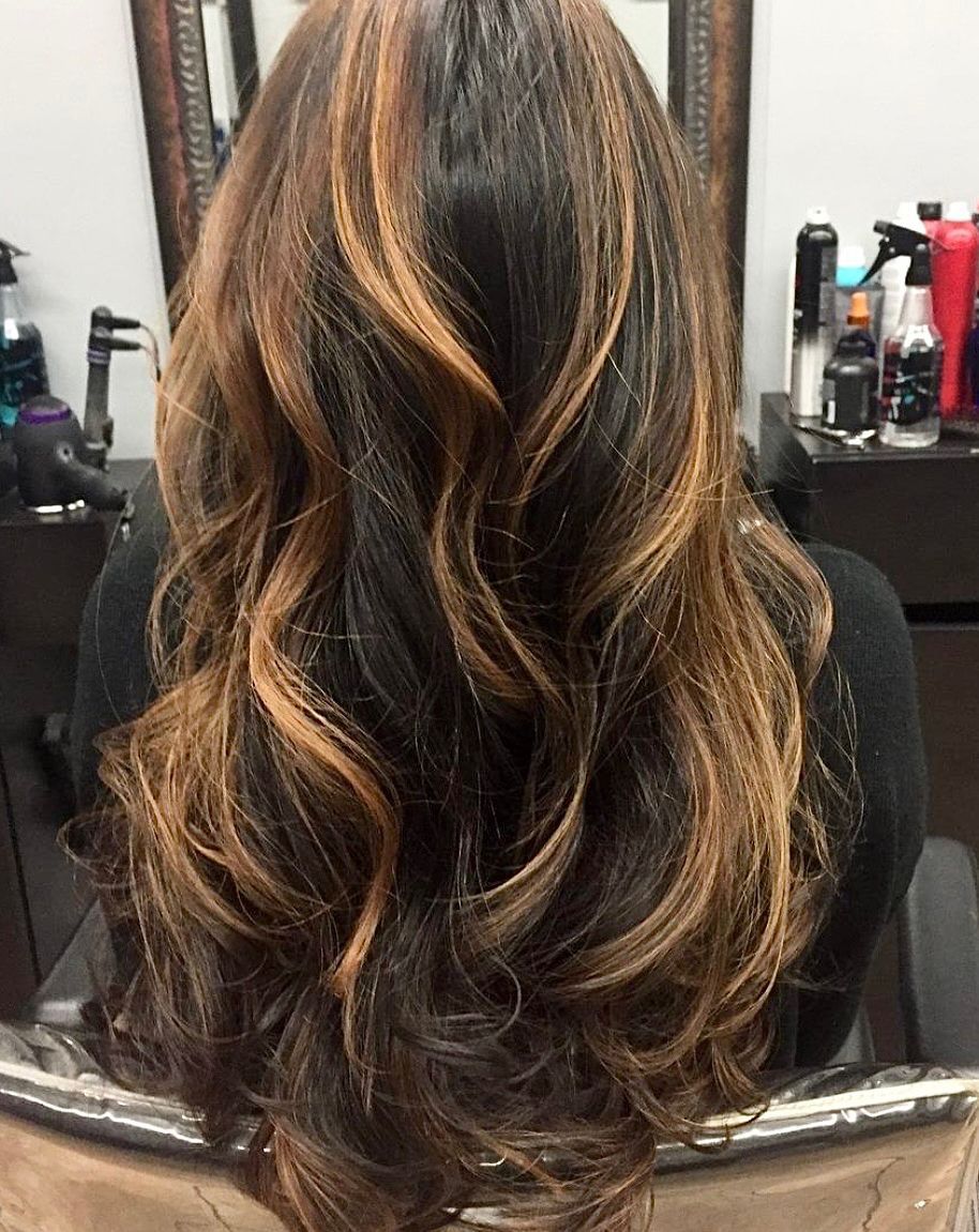 a woman with long hair is sitting in a chair in front of a mirror