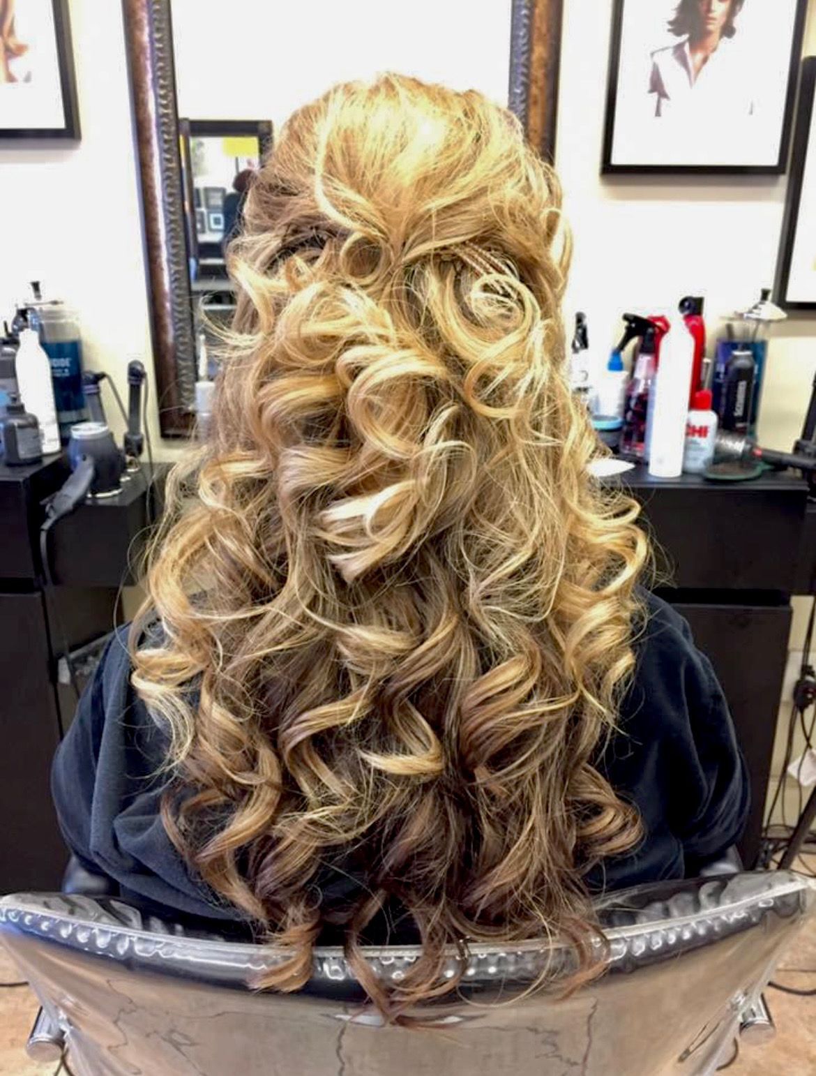 a woman is sitting in a chair with her hair in a half up half down hairstyle