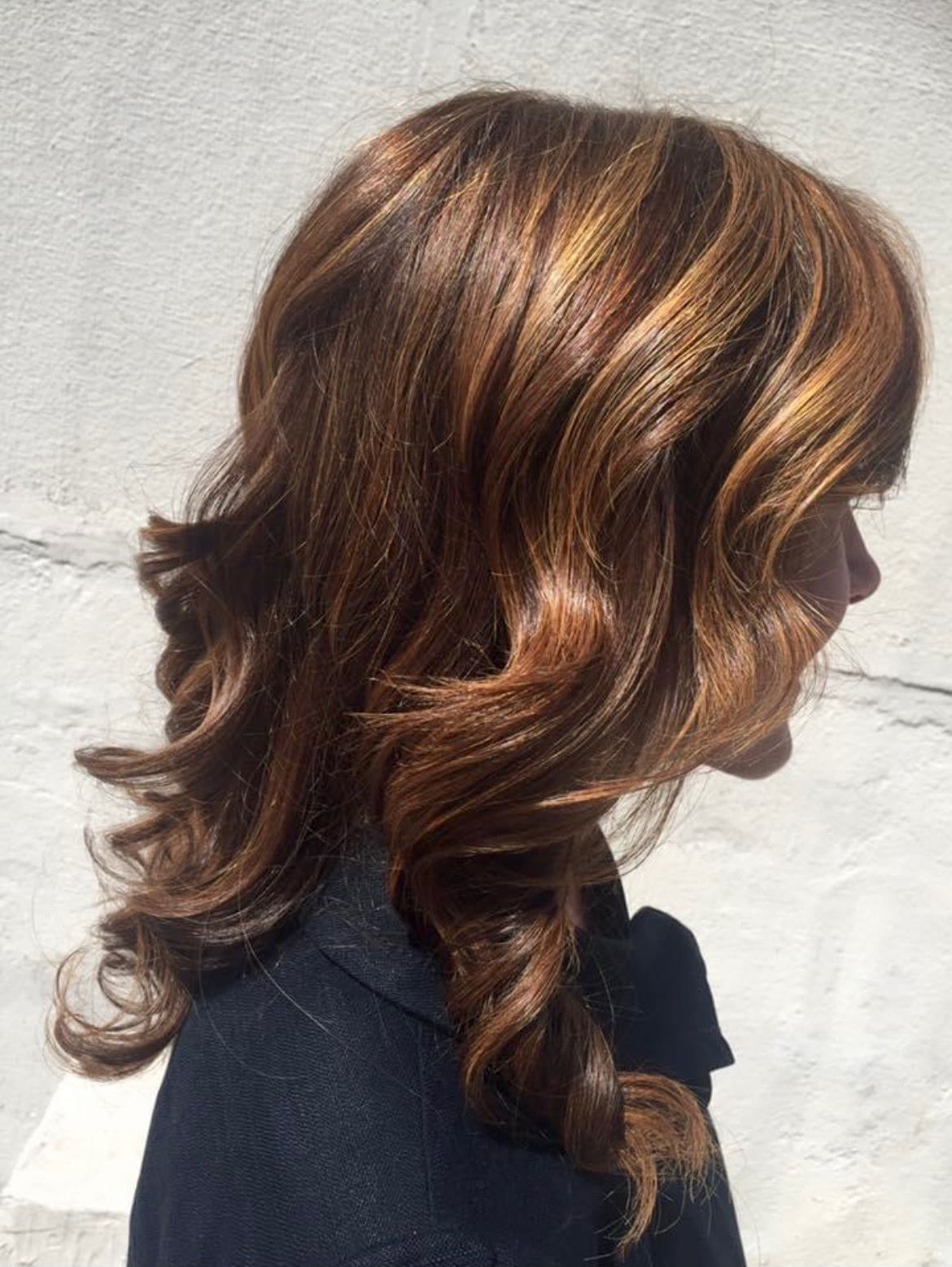 a woman with long brown hair is wearing a black jacket