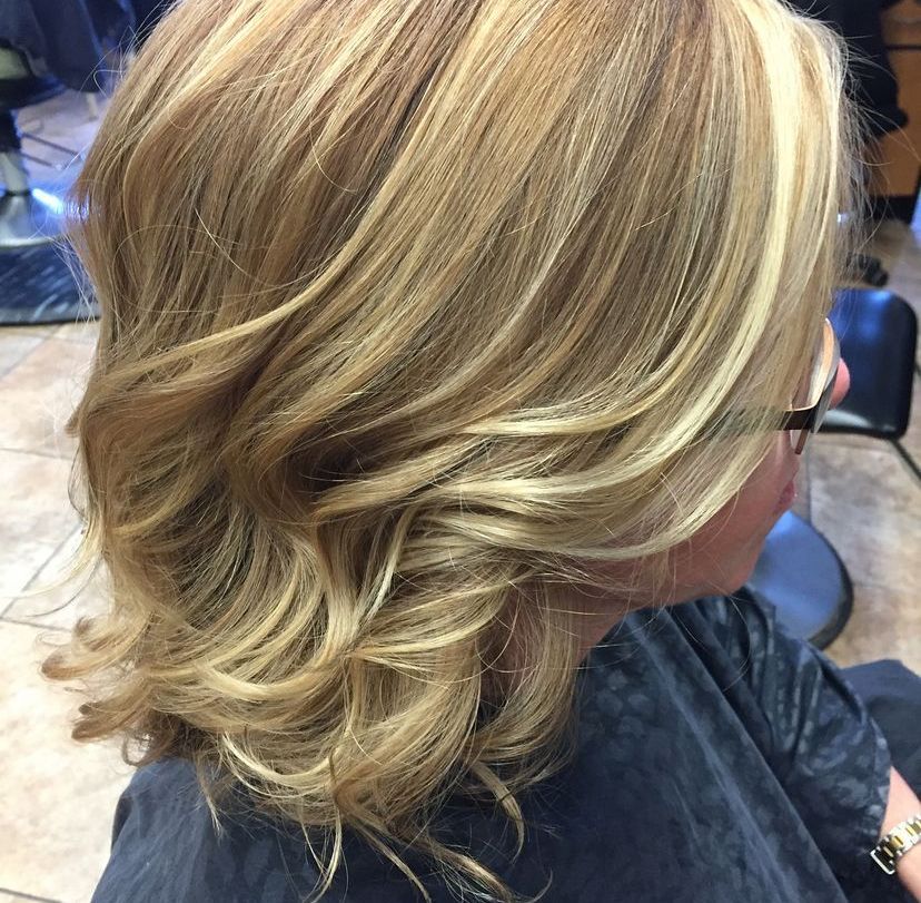 a woman with blonde hair is wearing glasses and a black cape