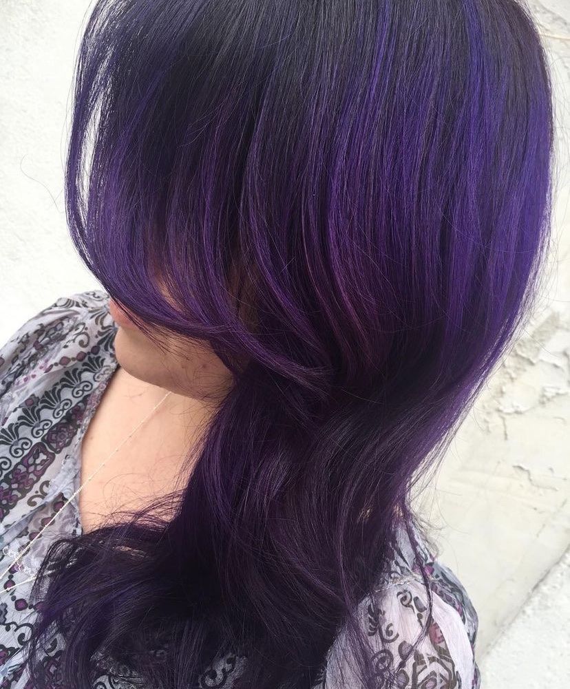 a woman with purple hair is wearing a floral shirt