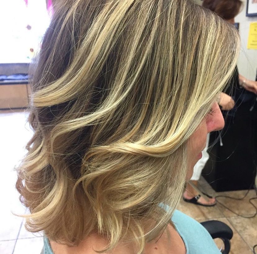 a woman with blonde hair is getting her hair done in a salon