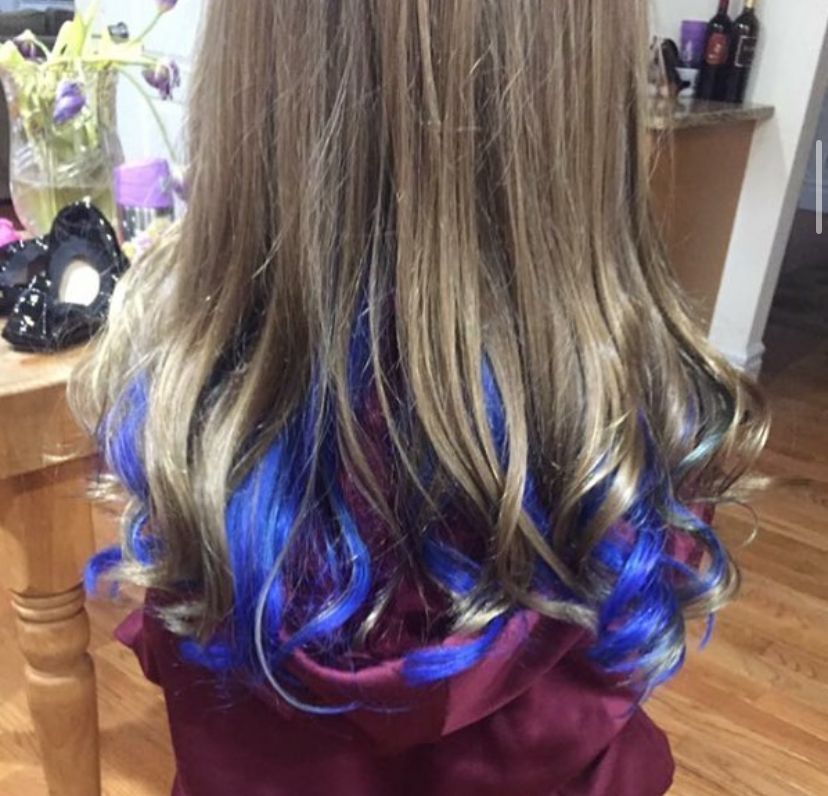 a woman with blue hair is sitting in front of a table