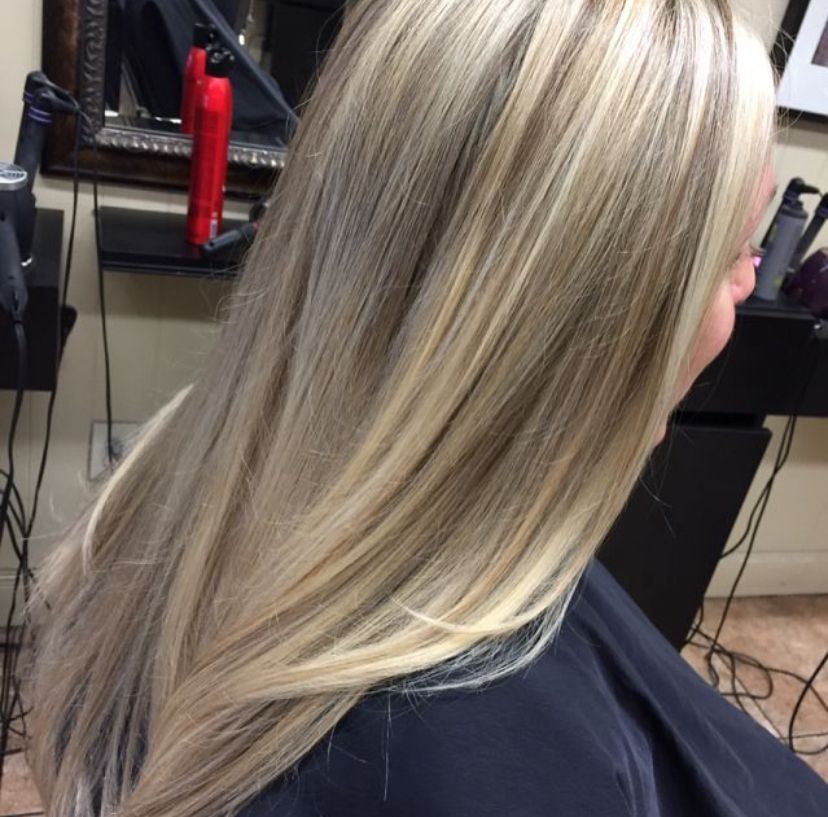 a woman with long blonde hair is sitting in a chair