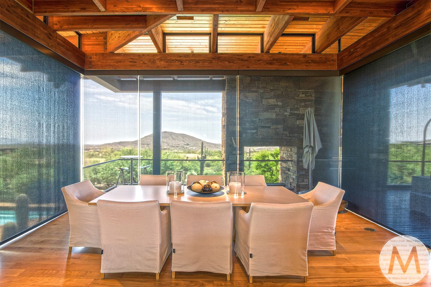 Dining room with a large table, white chairs, and a scenic mountain view.