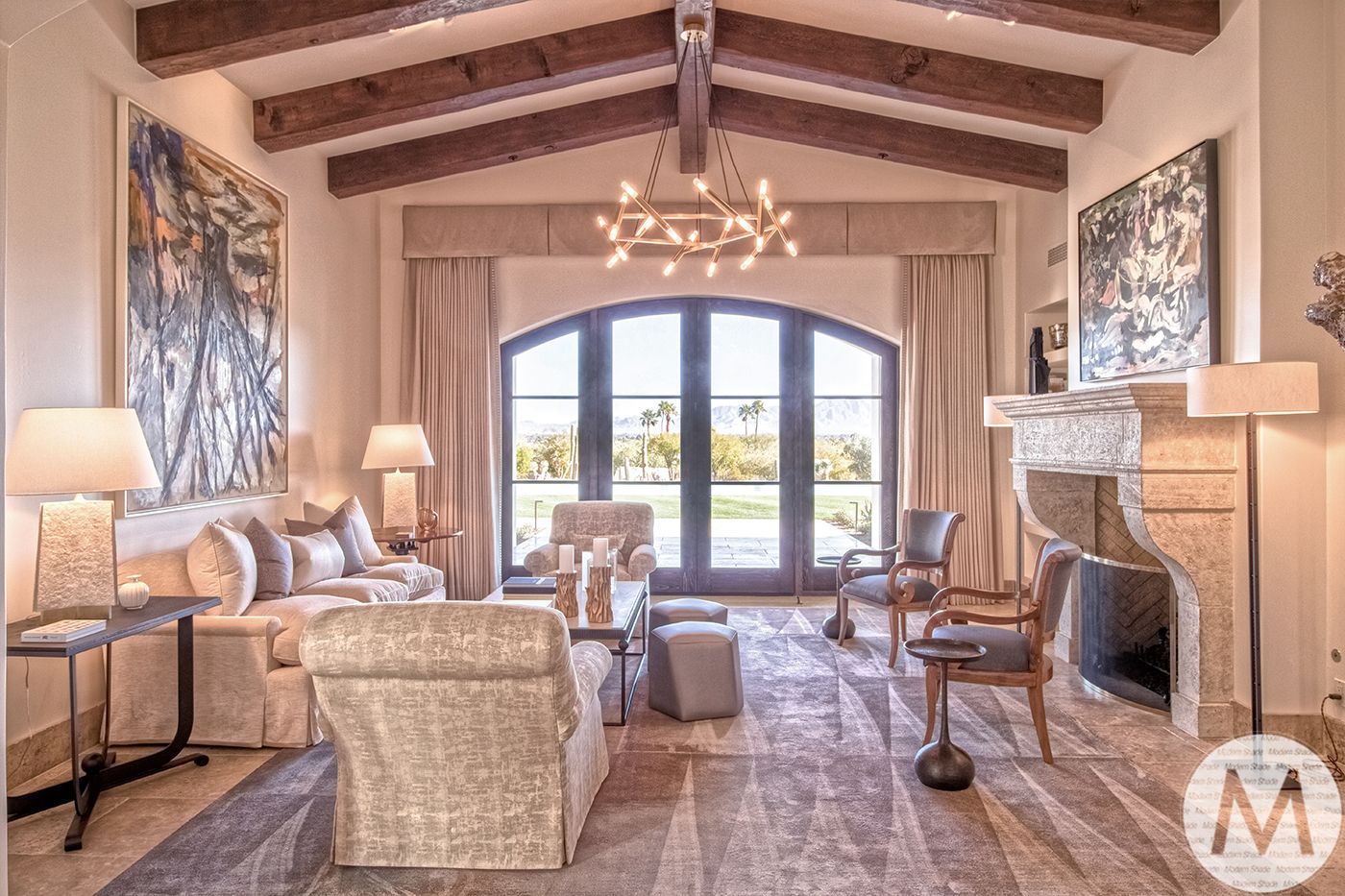 Living room with a large arched window, fireplace, and neutral tones.