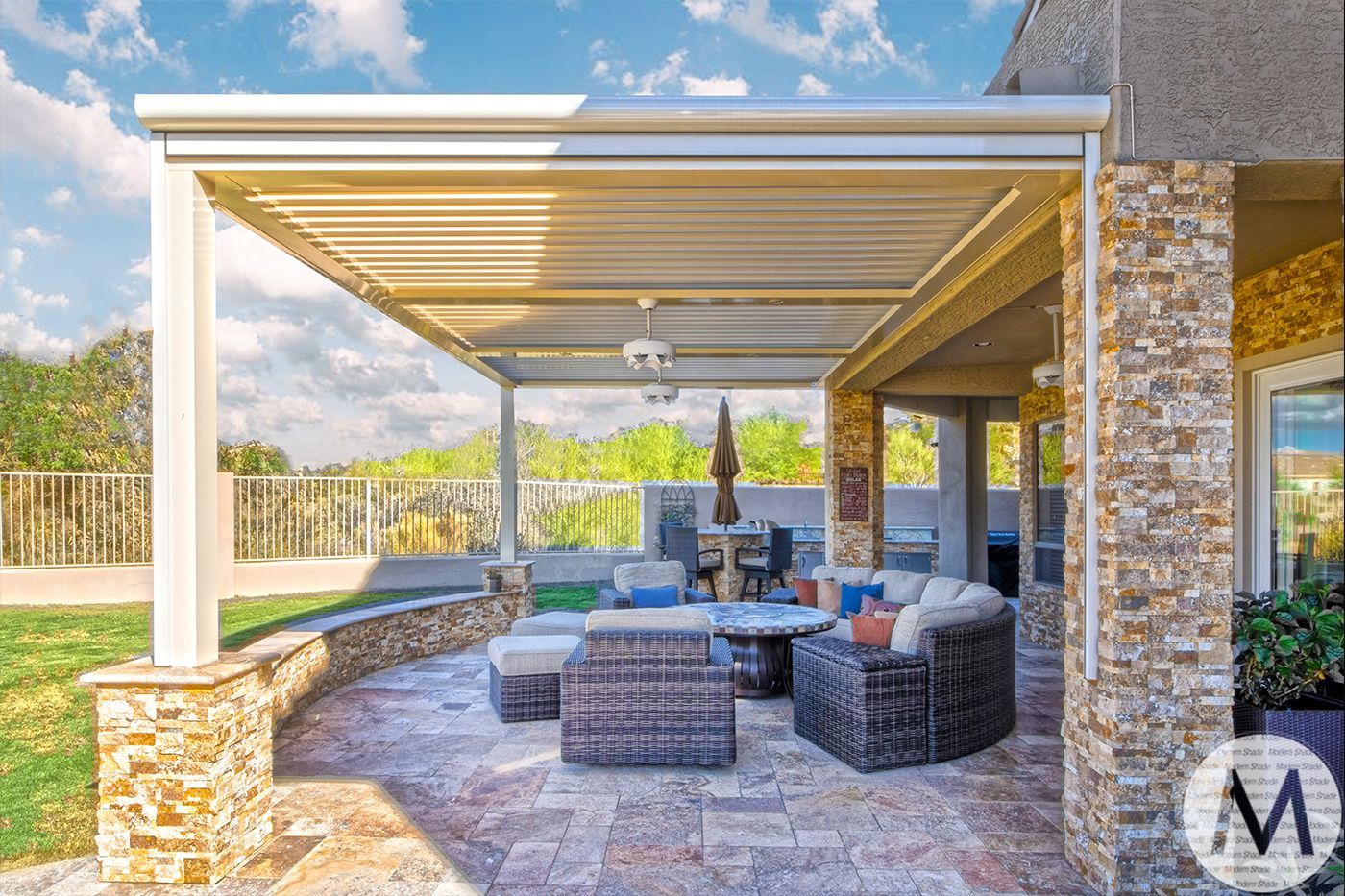 Patio with beige pergola, stone columns, seating area with furniture, and a view of the outdoors.