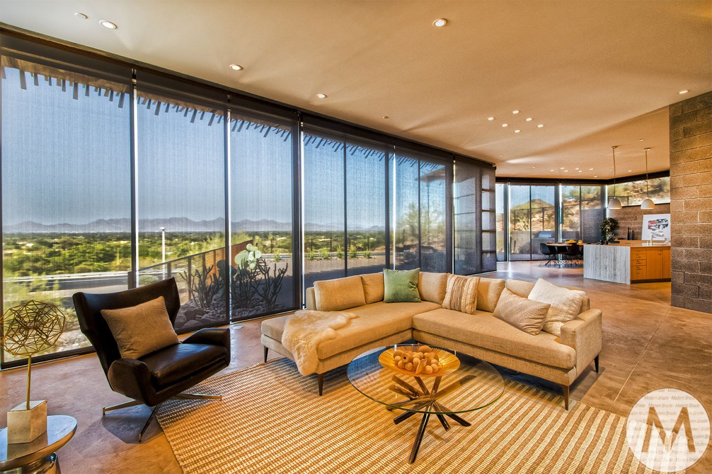 Spacious living room with a sectional sofa, armchair, and large windows offering a scenic view.