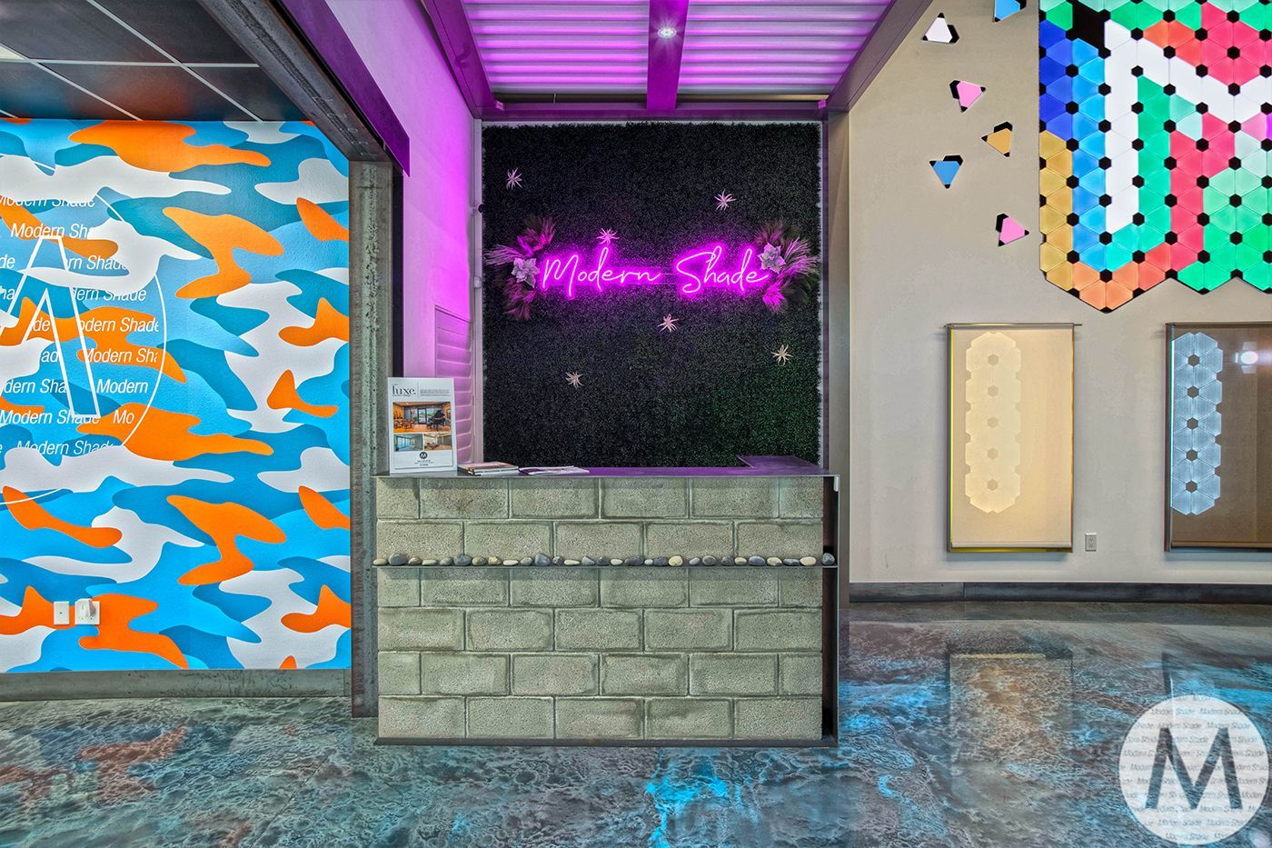 Reception desk with brick facade, Motion Studio sign, colorful graffiti-style art on walls.