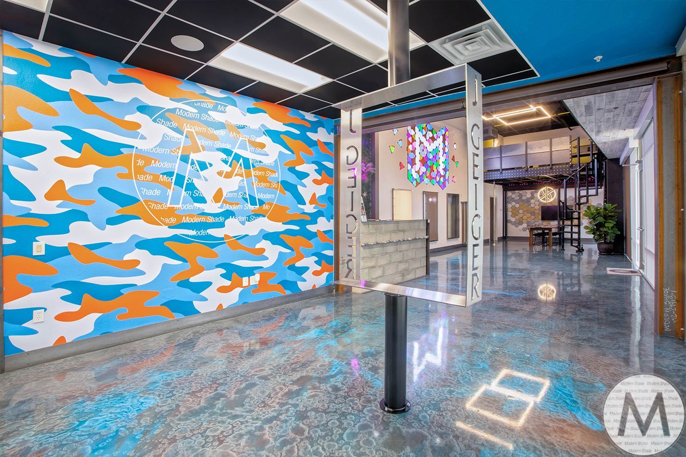 Colorful office interior with a camo wall, artistic accents, and a modern reception area.