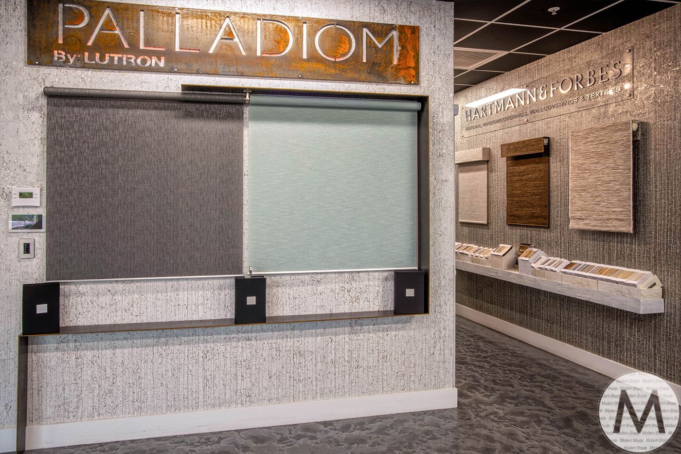Display of window shades and samples in a showroom; gray, beige, and brown colors.
