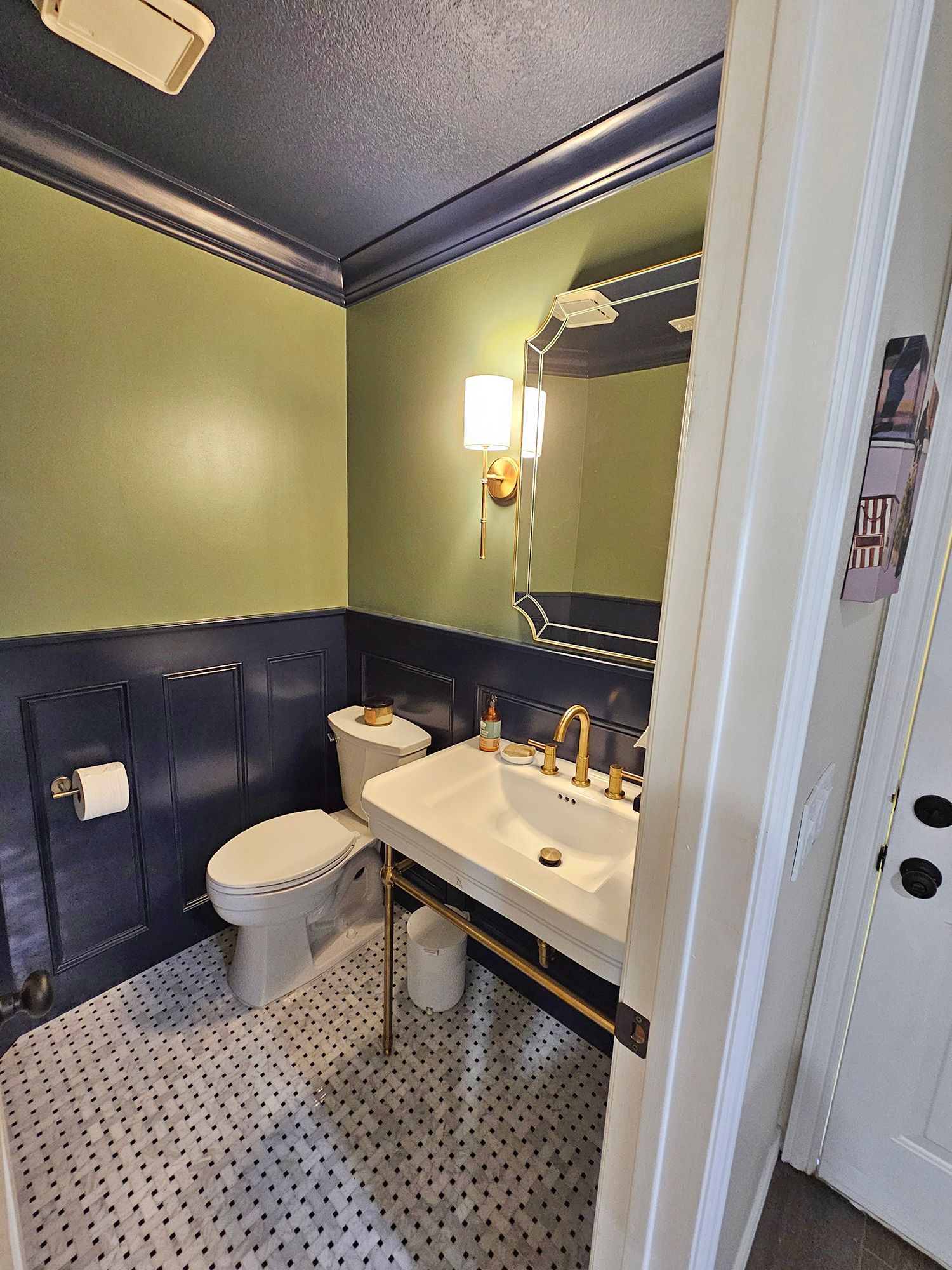 Small bathroom with blue and green walls, white toilet, sink, and patterned floor. - After