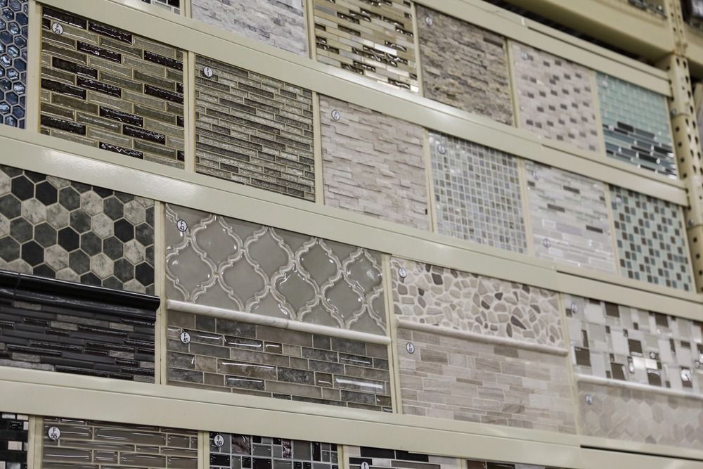 Display of various mosaic tiles on shelves in a store, showcasing textures and patterns.