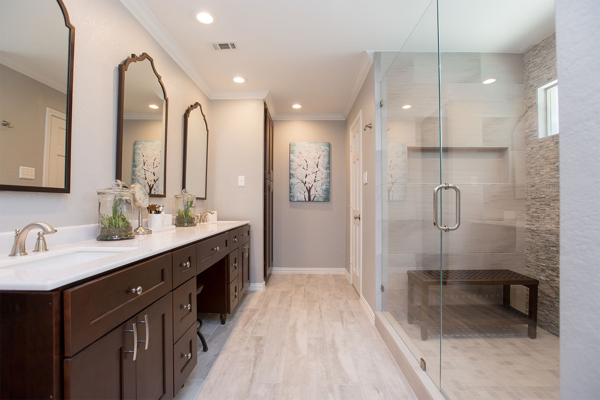 Spacious bathroom with dark wood vanity, glass shower, and neutral tones.