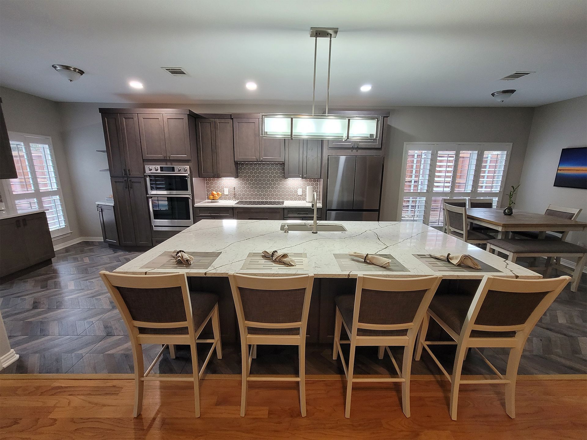 Modern kitchen with island seating and gray cabinets.