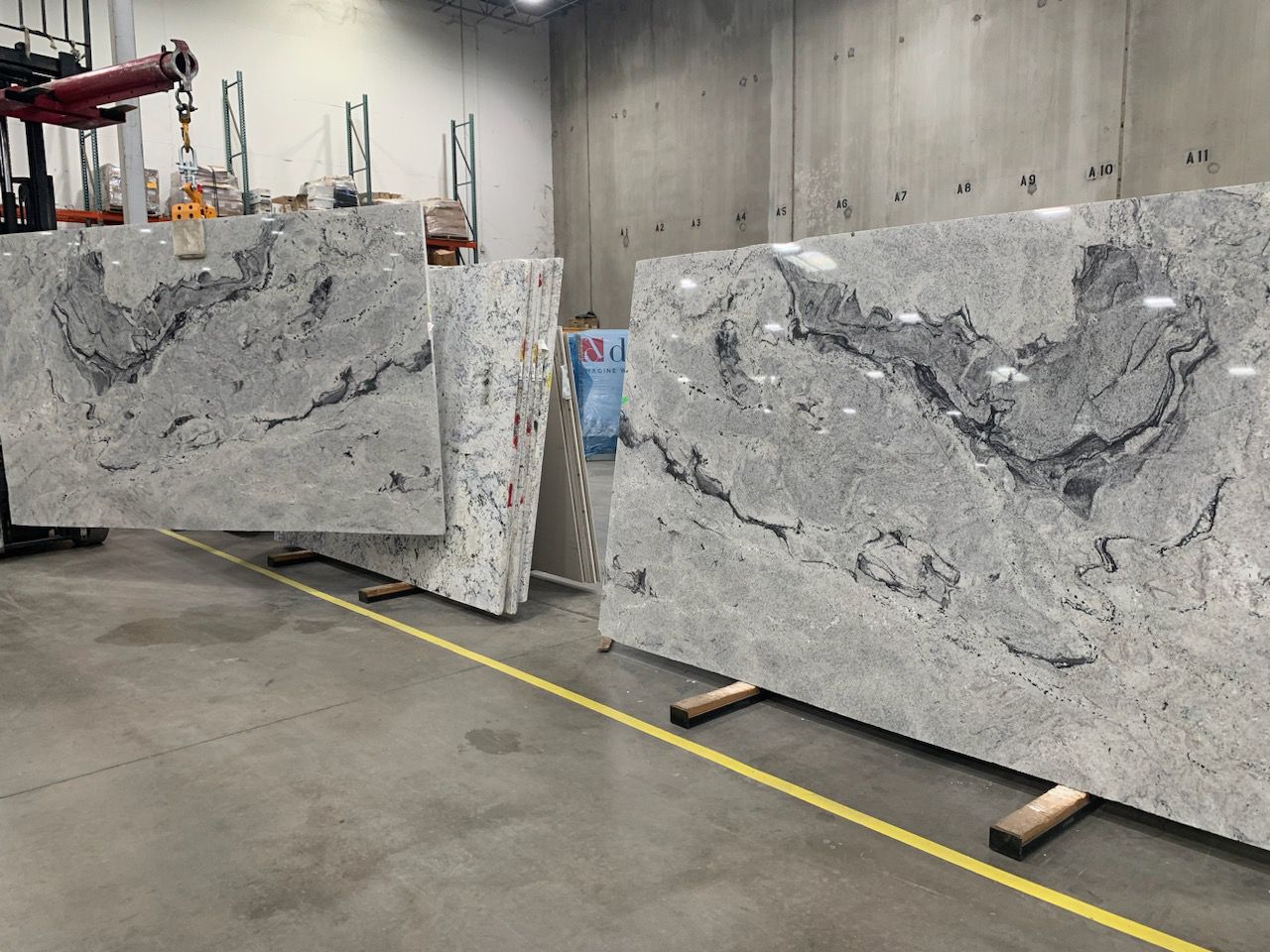 Large slabs of gray granite with dark veining, arranged in an industrial setting.