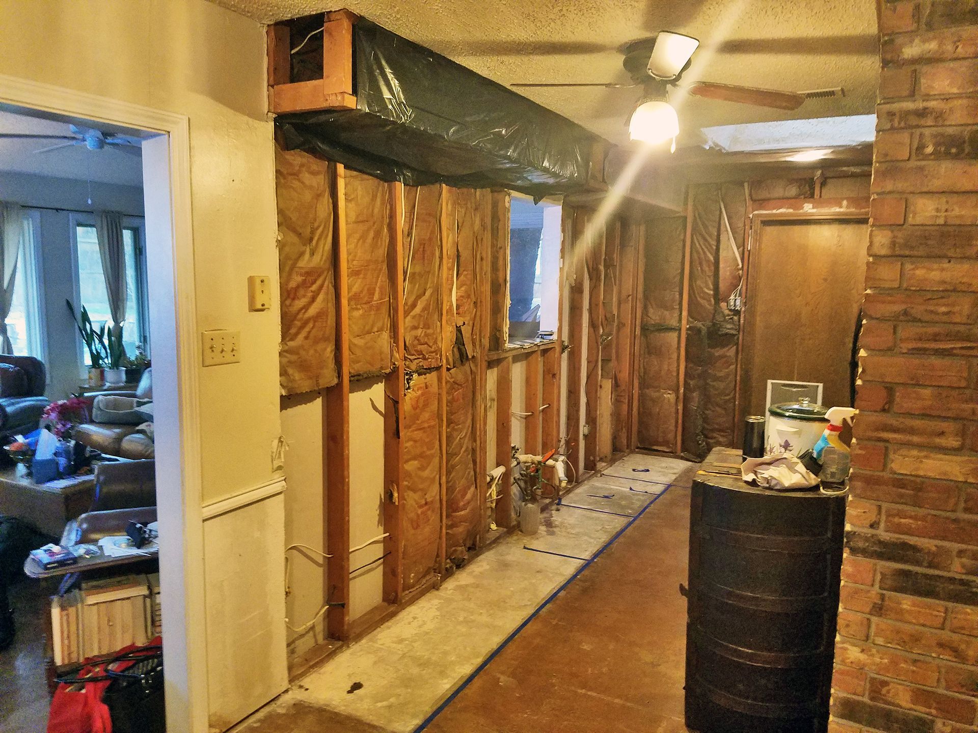 Interior hallway under construction, exposed wall studs, insulation visible.