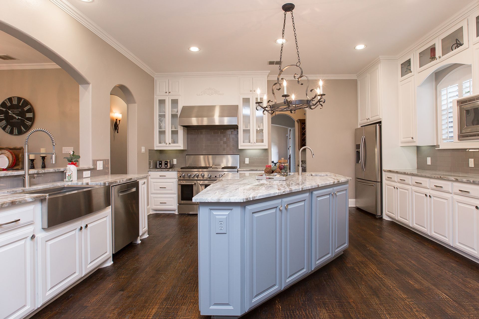 Spacious kitchen with island, stainless steel appliances, granite countertops, and dark wood floors.