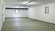 An empty garage with white walls and a concrete floor.