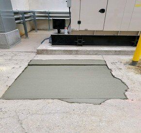 A piece of concrete is sitting on the ground next to a generator.