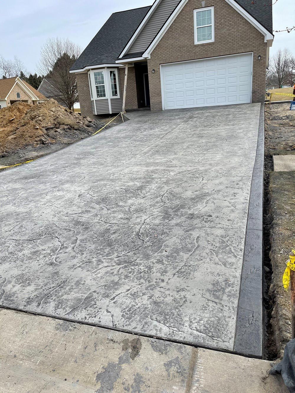 A concrete driveway is being built in front of a house.
