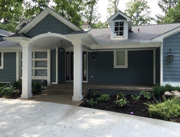A blue house with white trim and a porch