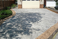 A concrete driveway with a garage door in the background.