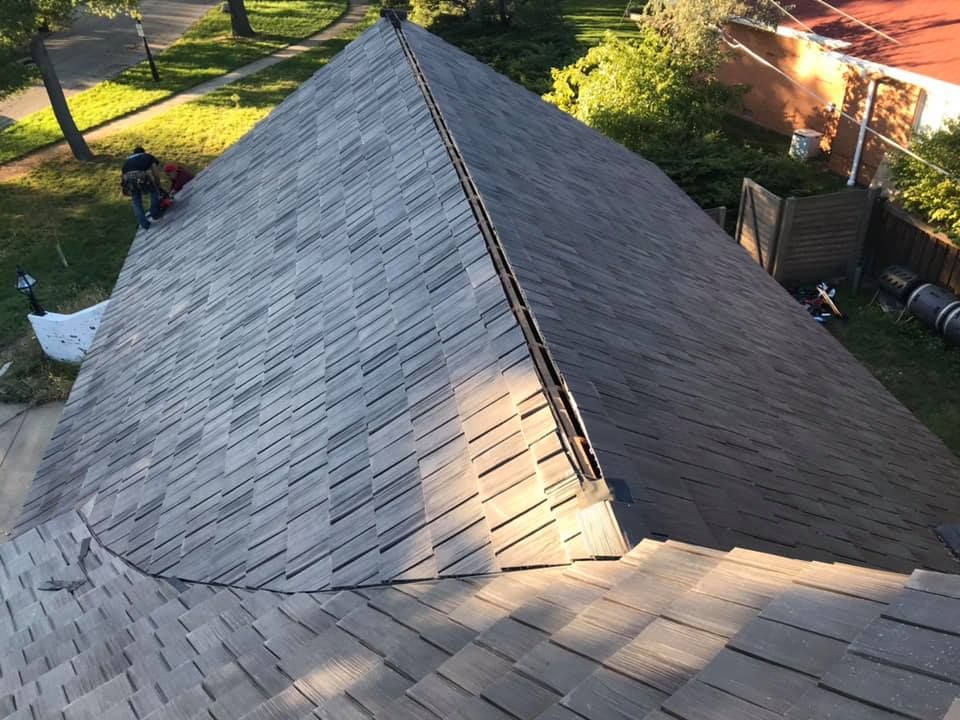 An aerial view of a roof with shingles being installed.