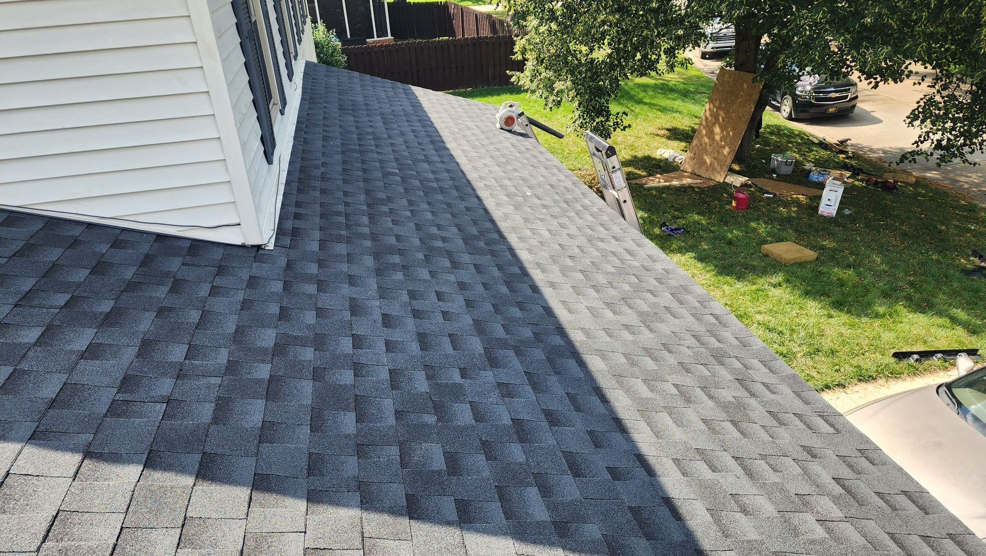 A roof with a lot of shingles on it is being installed on a house.