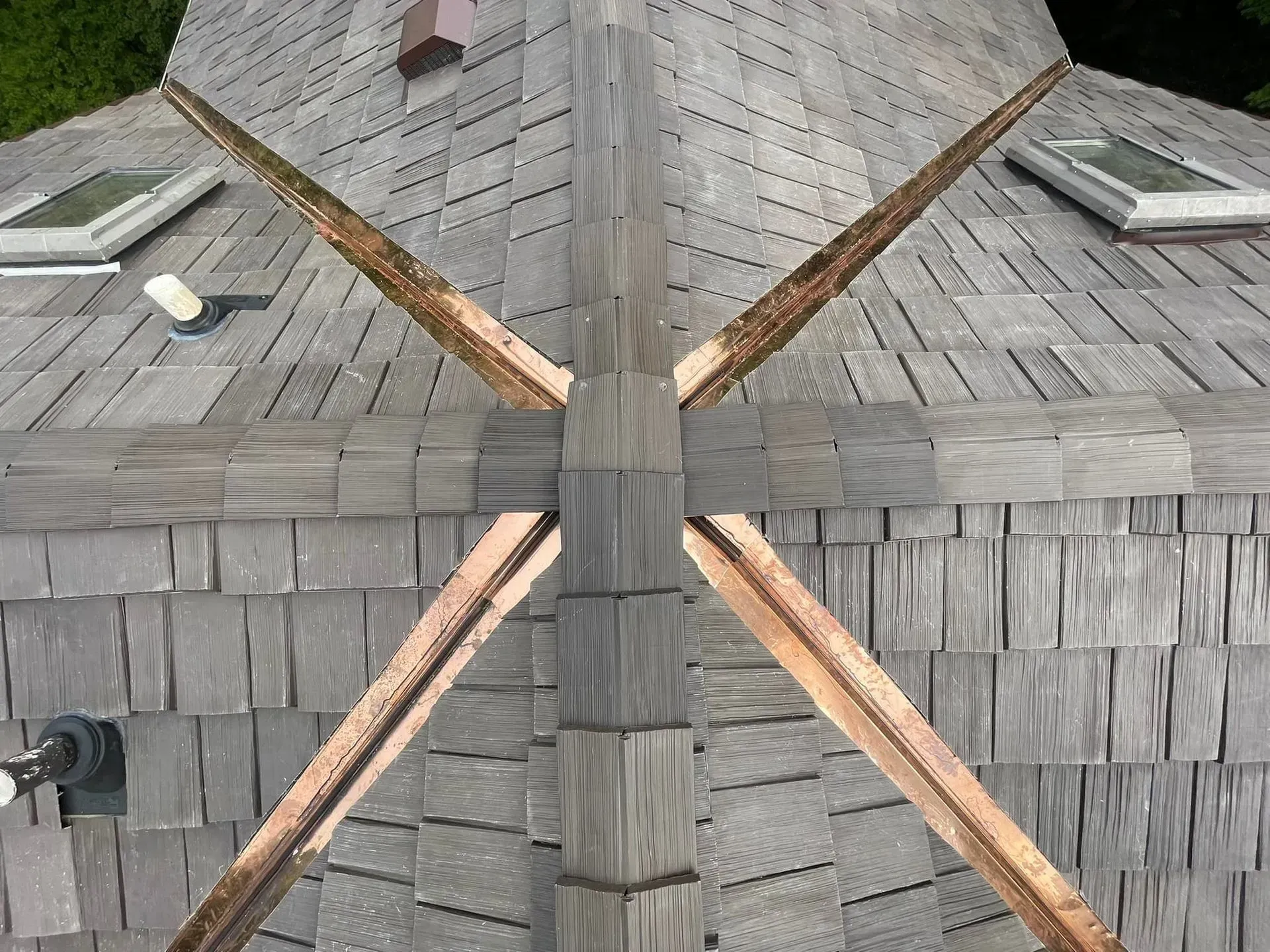 A wooden roof with copper trim and skylights on it.