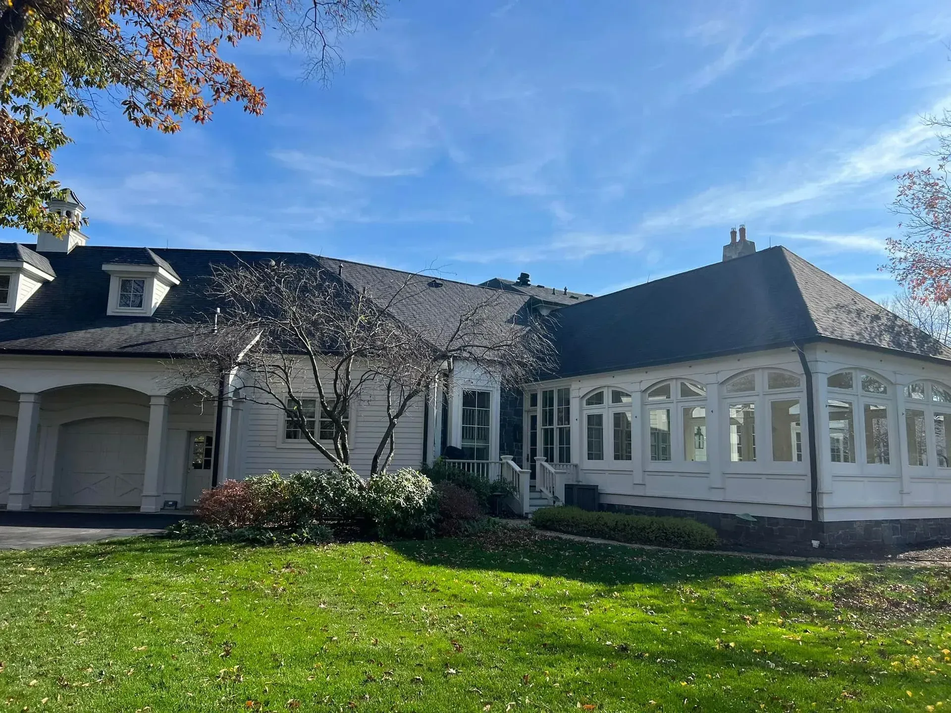 A large white house with a black roof and a lot of windows.