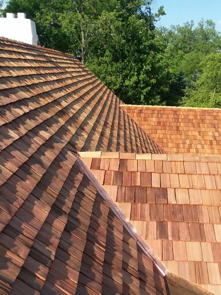 A close up of a wooden roof with trees in the background.
