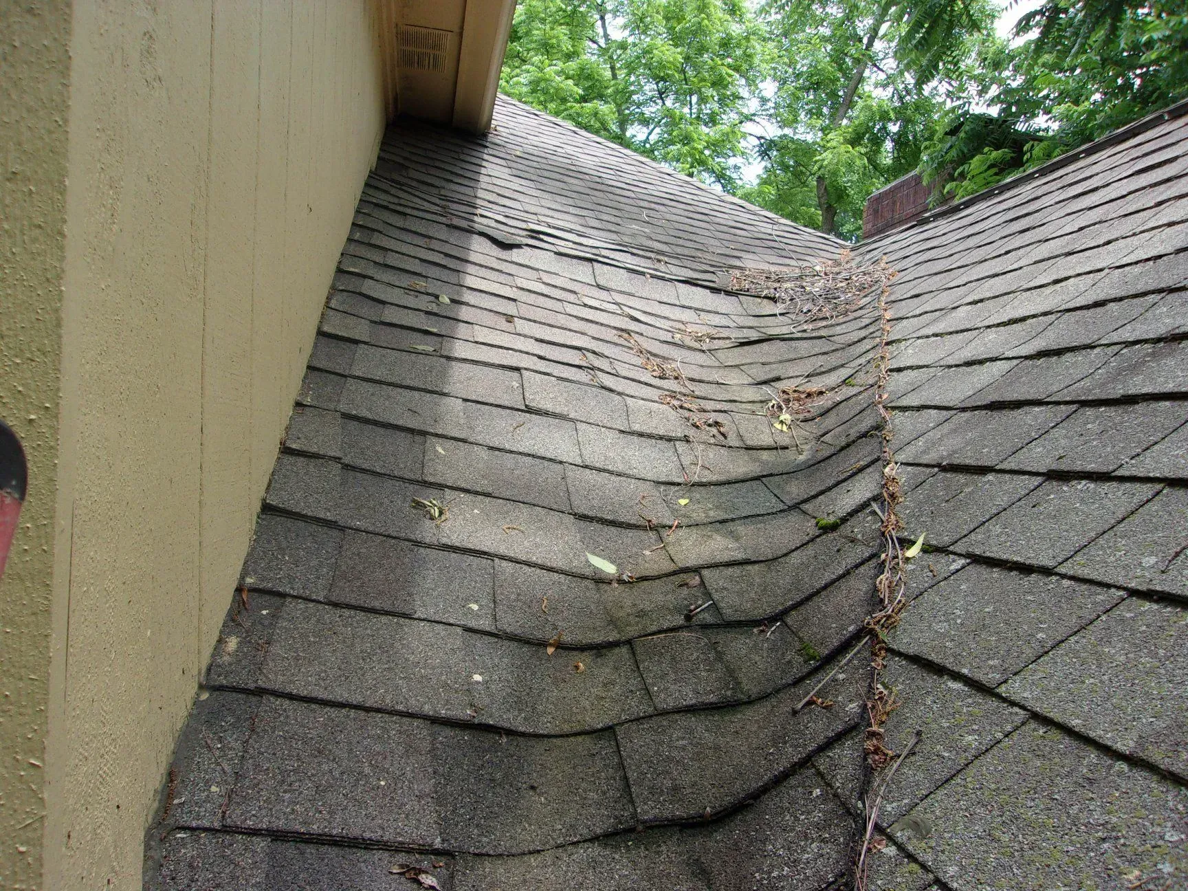 A close up of a roof with shingles that are missing and broken.