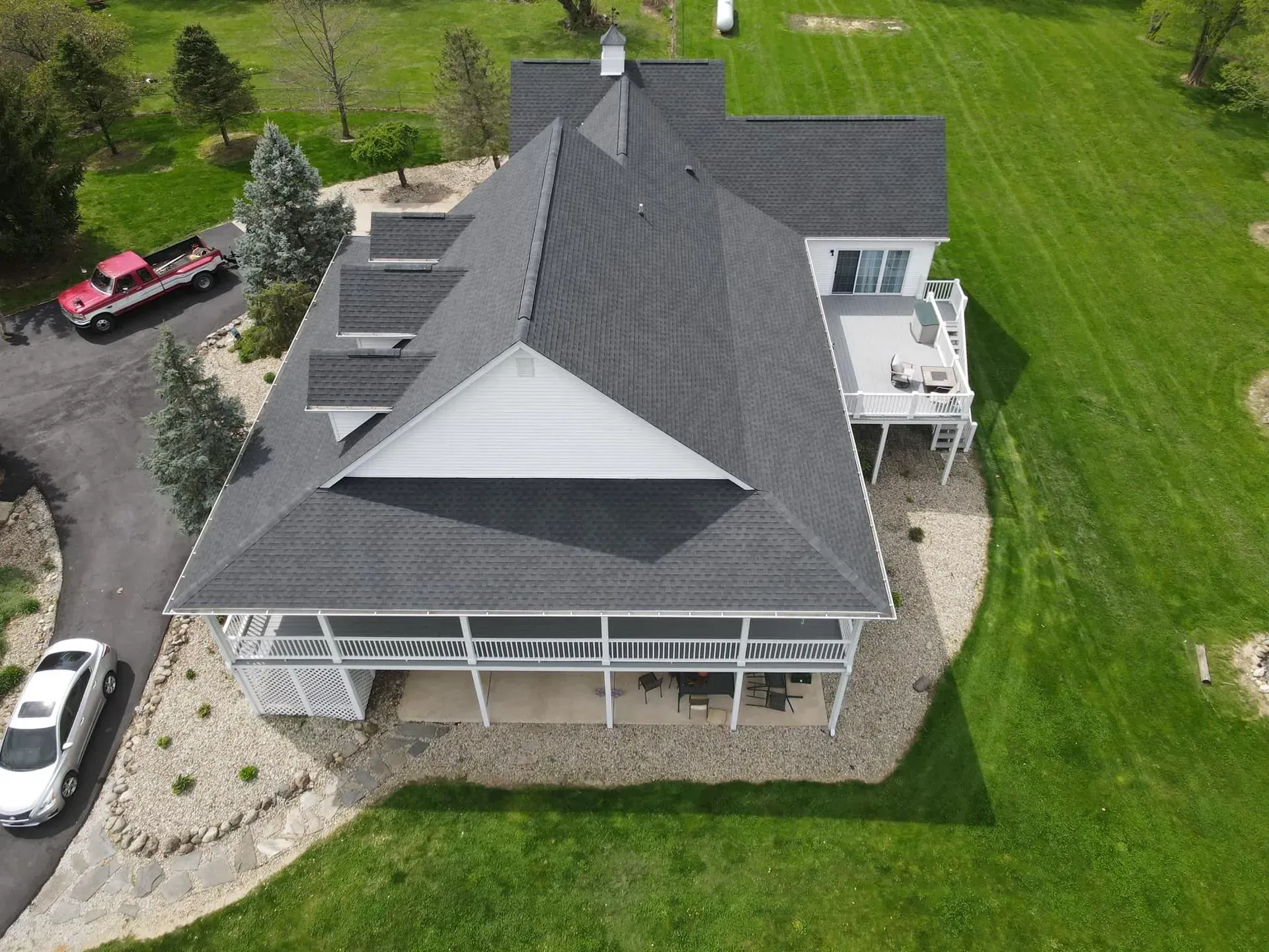 An aerial view of a large house with a black roof.