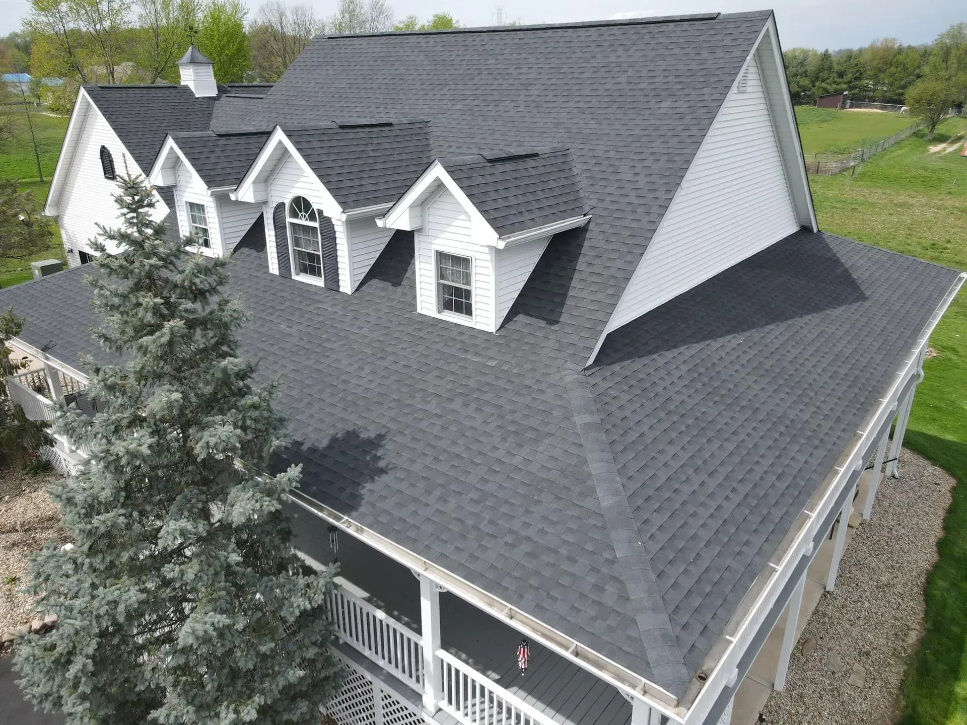 A large house with a black roof and white trim.