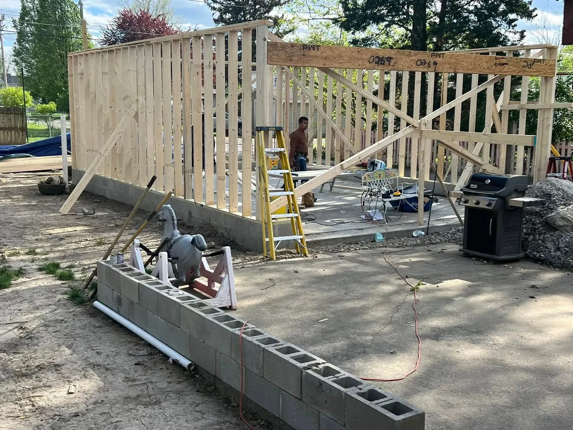 A man is standing in front of a building under construction.