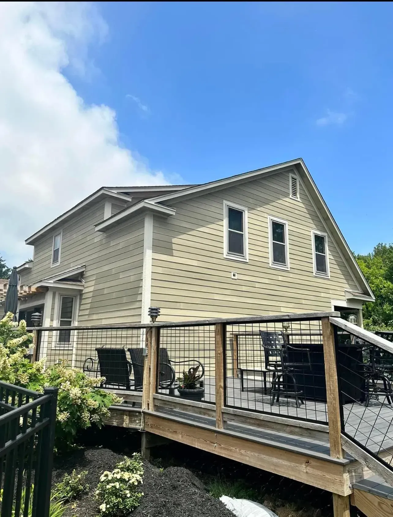A house with a deck and chairs on it.