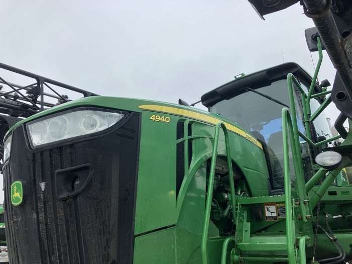 Green John Deere tractor cab and hood close-up at a farm equipment lot