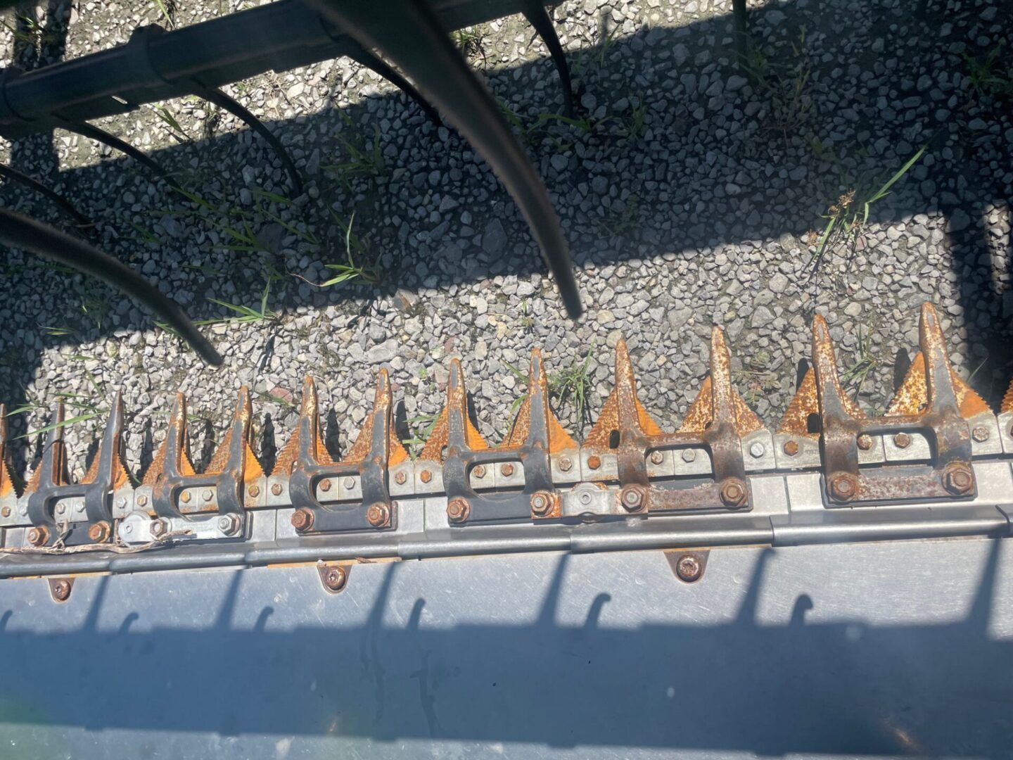 Close-up of a metal fence with orange-tipped spikes above a gravel surface