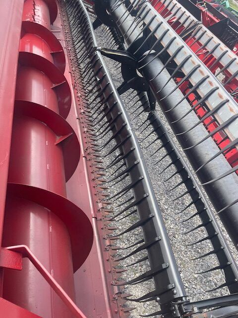 Close-up of red and gray industrial machinery with cables and metal rails