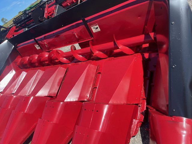 Close-up of a red industrial machine with glossy panels and mechanical parts.